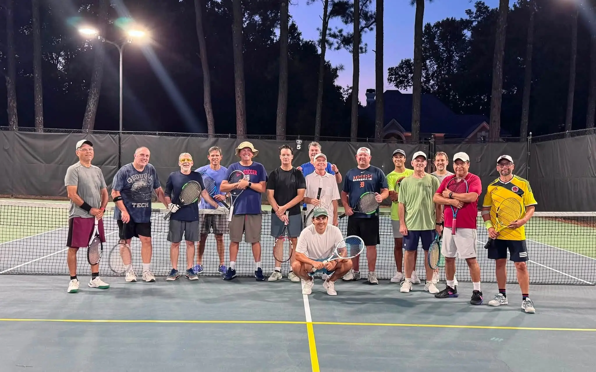 The men's drill group at the net under the lights at Crooked Creek